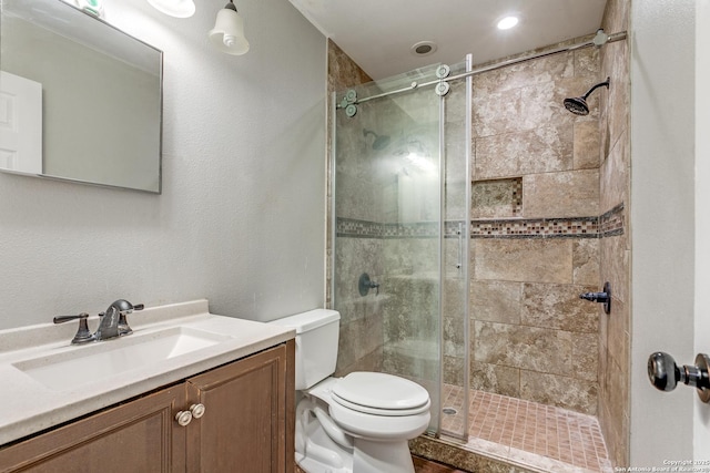 bathroom with toilet, vanity, and walk in shower