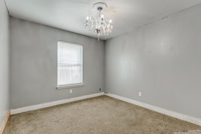 carpeted empty room with an inviting chandelier