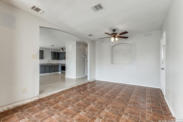 empty room featuring ceiling fan and sink