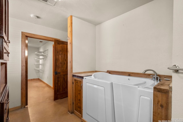 bathroom featuring concrete floors and a bathing tub