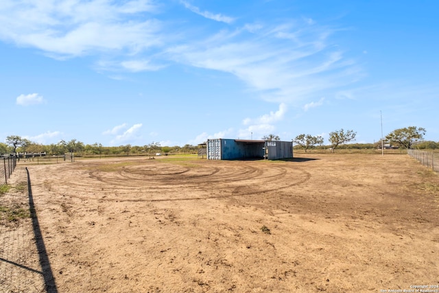 view of yard with an outdoor structure and a rural view