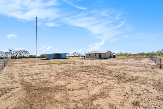 view of yard featuring a rural view and an outdoor structure