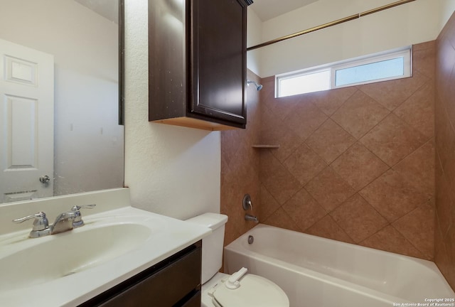 full bathroom featuring tiled shower / bath, vanity, and toilet