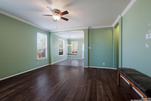 unfurnished room with dark wood-type flooring, ornamental molding, and ceiling fan with notable chandelier