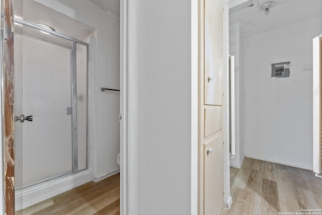 bathroom with hardwood / wood-style flooring, toilet, and walk in shower