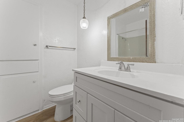 bathroom with vanity, hardwood / wood-style floors, toilet, and walk in shower