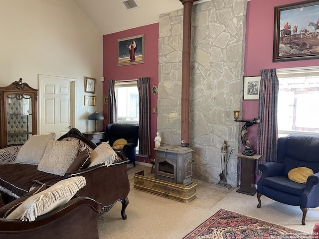 living room featuring light colored carpet, high vaulted ceiling, and a wood stove