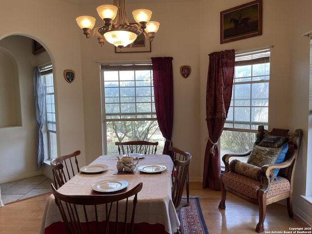 dining space with plenty of natural light, light wood-type flooring, and a chandelier