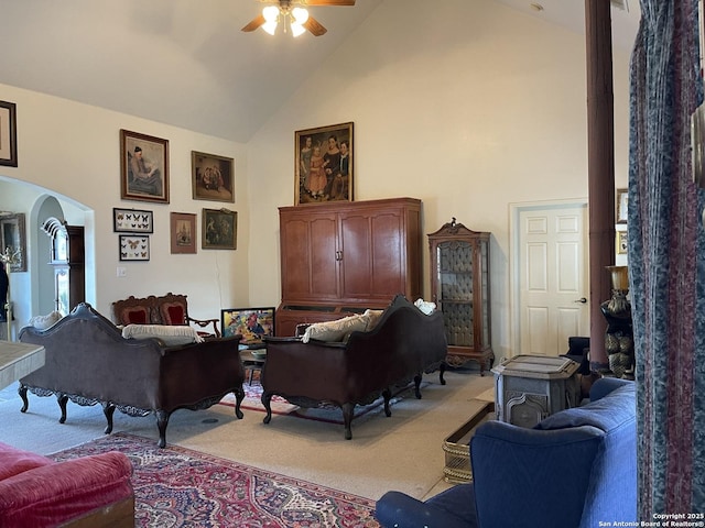 carpeted living room featuring high vaulted ceiling and ceiling fan