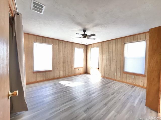 unfurnished room with ornamental molding, a wealth of natural light, light hardwood / wood-style floors, and ceiling fan