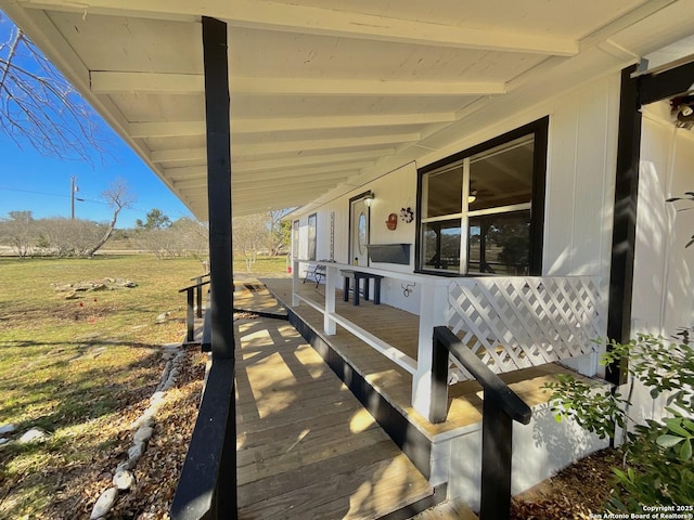 wooden deck with a yard and covered porch