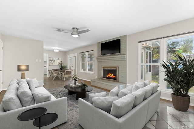 living room with a brick fireplace and ceiling fan