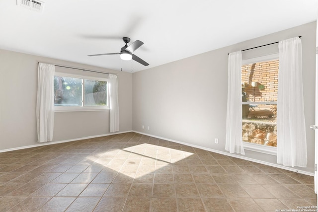 tiled spare room with ceiling fan