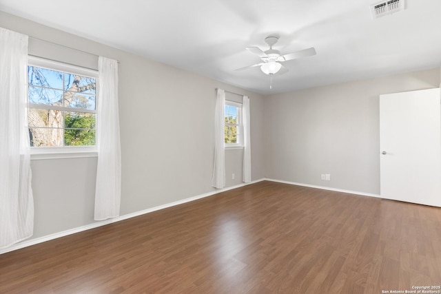 empty room with dark hardwood / wood-style floors and ceiling fan