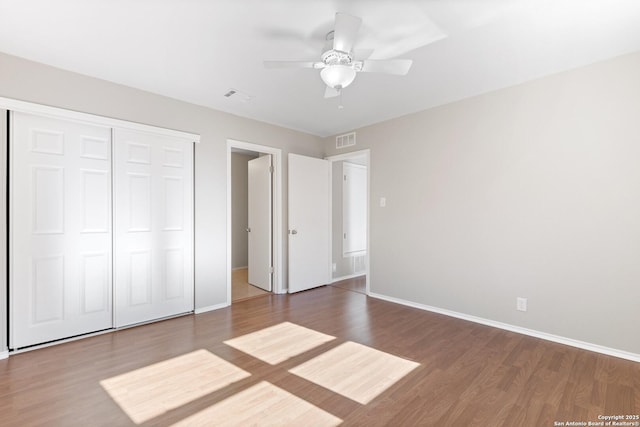 unfurnished bedroom with wood-type flooring, ceiling fan, and a closet