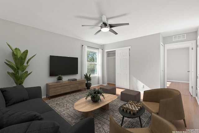 living room with ceiling fan and light wood-type flooring