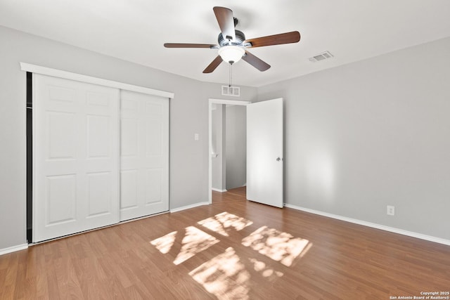 unfurnished bedroom with hardwood / wood-style flooring, ceiling fan, and a closet