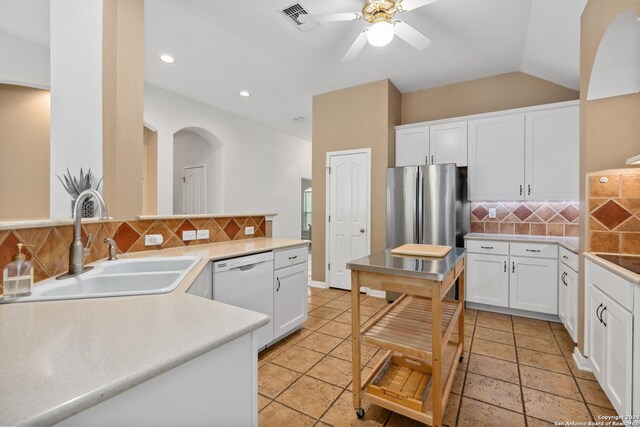 kitchen with stainless steel refrigerator, dishwasher, sink, backsplash, and white cabinets