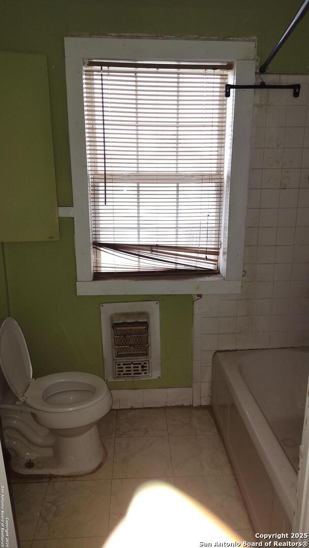 1601 Fulton Ave, San Antonio, TX 78201 - full bath featuring plenty of natural light, toilet, heating unit, and marble finish flooring