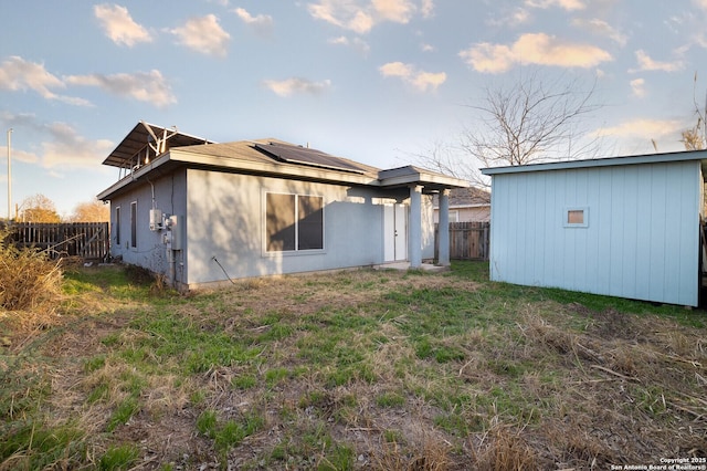 rear view of property with solar panels