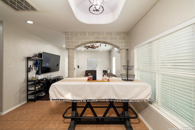 dining area with tile patterned floors and a raised ceiling