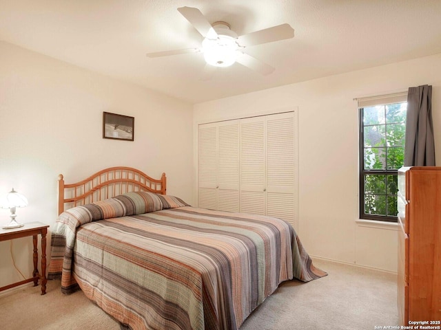 carpeted bedroom featuring ceiling fan and a closet