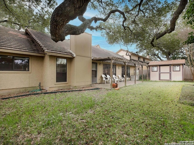 back of house featuring a storage shed, a patio, a lawn, and a pergola