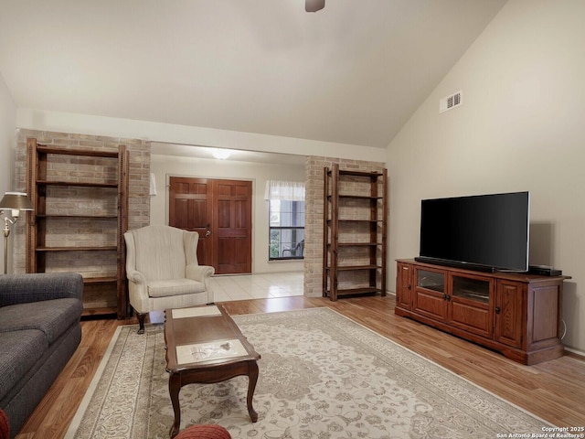 living room featuring vaulted ceiling and light hardwood / wood-style flooring