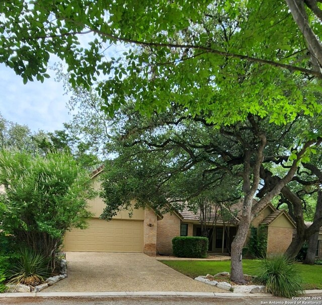 106 Saddle Club Cir, Boerne, TX 78006 - obstructed view of property featuring driveway, a garage, and brick siding