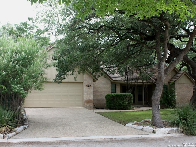 106 Saddle Club Cir, Boerne, TX 78006 - view of property hidden behind natural elements featuring brick siding, concrete driveway, and a garage