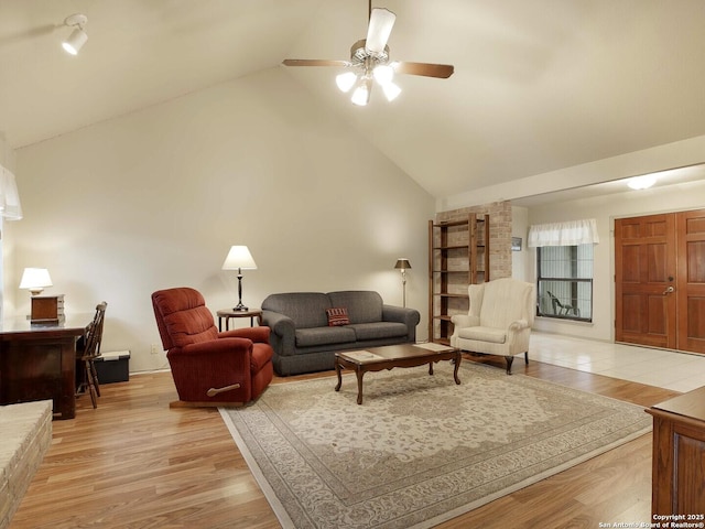 living room featuring light hardwood / wood-style flooring, high vaulted ceiling, and ceiling fan