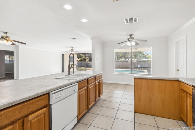 kitchen featuring a healthy amount of sunlight, white dishwasher, sink, and light tile patterned floors