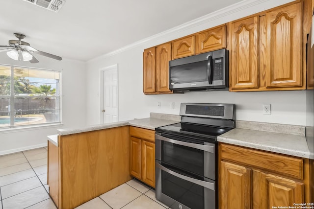 kitchen with range with two ovens, light tile patterned flooring, ornamental molding, and ceiling fan