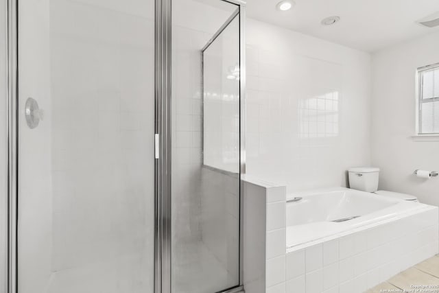 bathroom featuring tile patterned flooring, toilet, and separate shower and tub