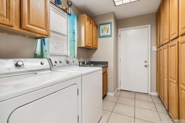 laundry room featuring sink, light tile patterned floors, washing machine and dryer, and cabinets