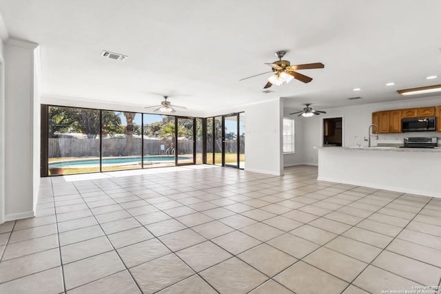 unfurnished living room featuring light tile patterned flooring and sink