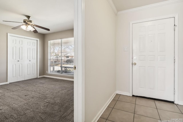 foyer entrance featuring crown molding, ceiling fan, and light tile patterned flooring