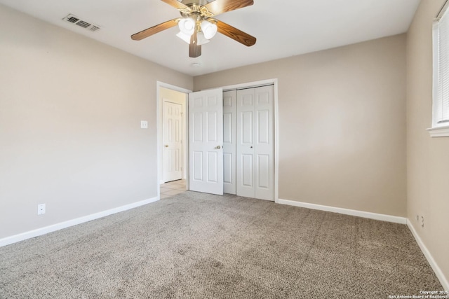 unfurnished bedroom with light colored carpet, ceiling fan, and a closet