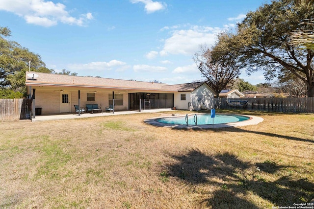 back of property with a fenced in pool, a patio, and a yard