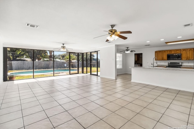 unfurnished living room featuring sink and light tile patterned floors