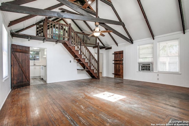 unfurnished living room featuring beam ceiling, high vaulted ceiling, cooling unit, a barn door, and hardwood / wood-style floors