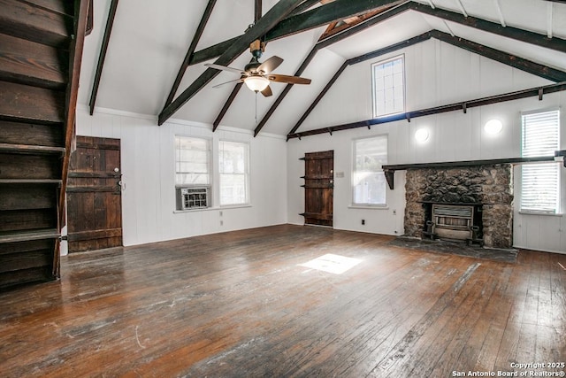 unfurnished living room with dark wood-type flooring, ceiling fan, beam ceiling, high vaulted ceiling, and a stone fireplace