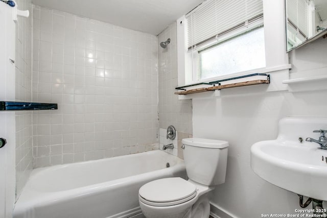 full bathroom featuring tiled shower / bath, sink, and toilet