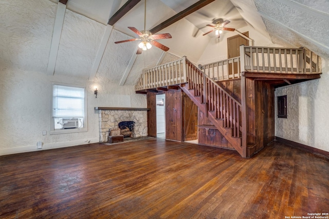 unfurnished living room featuring a stone fireplace, dark hardwood / wood-style floors, and ceiling fan