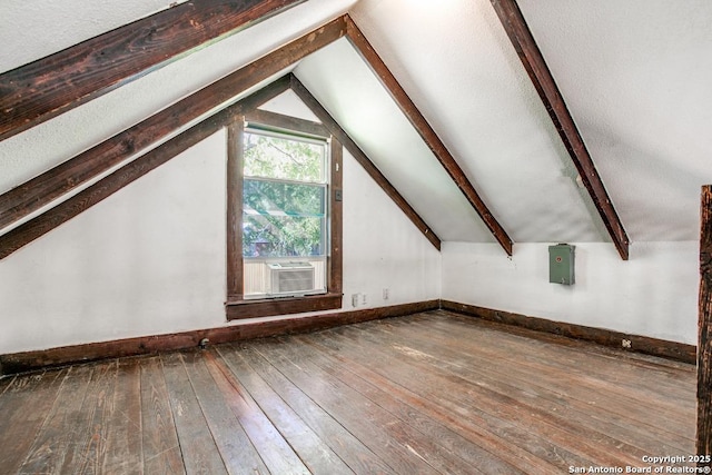 additional living space with cooling unit, hardwood / wood-style flooring, lofted ceiling with beams, and electric panel