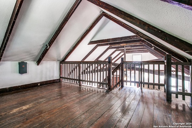 bonus room featuring hardwood / wood-style flooring, vaulted ceiling with beams, and a textured ceiling