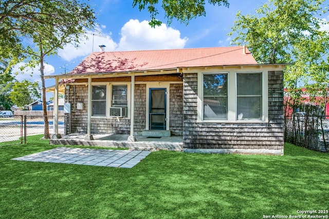 view of front facade with cooling unit, a front yard, and a patio