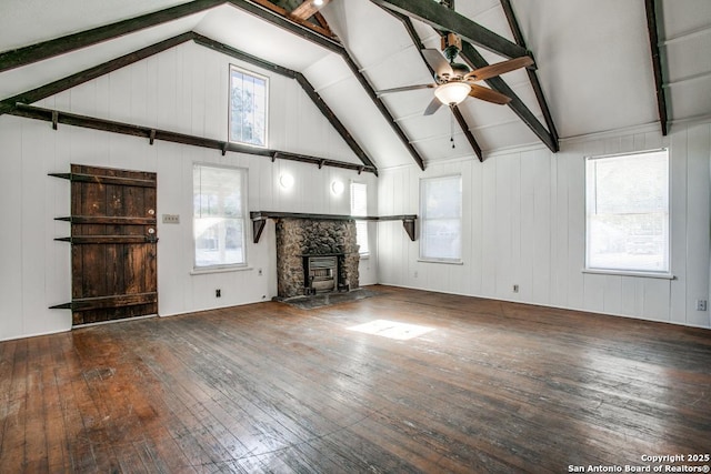 unfurnished living room with hardwood / wood-style flooring, a fireplace, ceiling fan, and lofted ceiling with beams