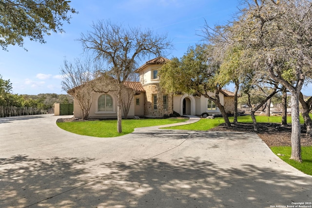 mediterranean / spanish home with a front yard