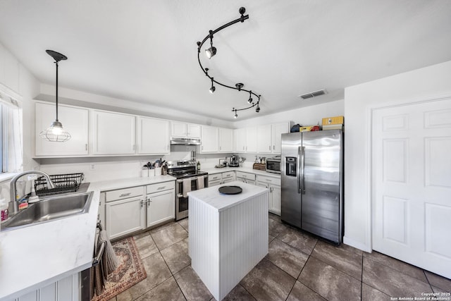 kitchen featuring sink, decorative light fixtures, a center island, stainless steel appliances, and white cabinets